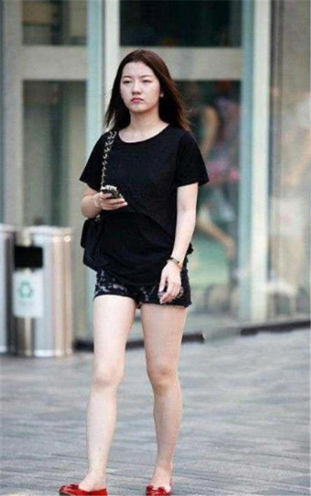  白皙：街拍：小姐姐身材窈窕，黑色短袖+背带短裤，白皙的大长腿吸睛满满