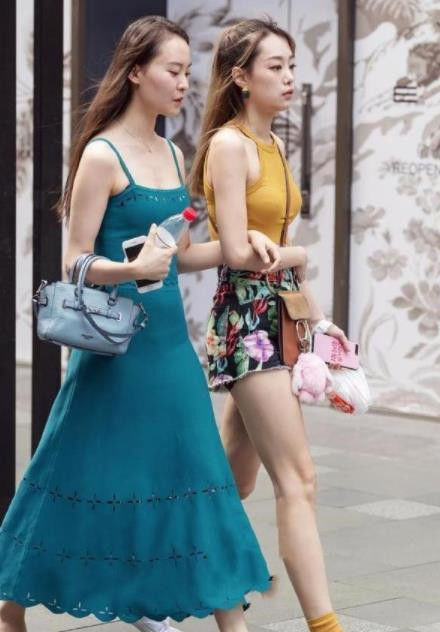  白皙：街拍：小姐姐身材窈窕，黑色短袖+背带短裤，白皙的大长腿吸睛满满