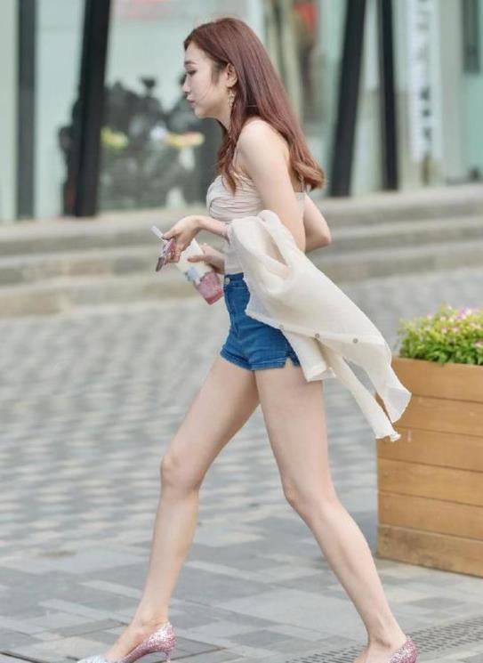  『小美女』街拍：小美女身穿紧身小吊带，左手挽了件薄外套，很显飘逸的美感