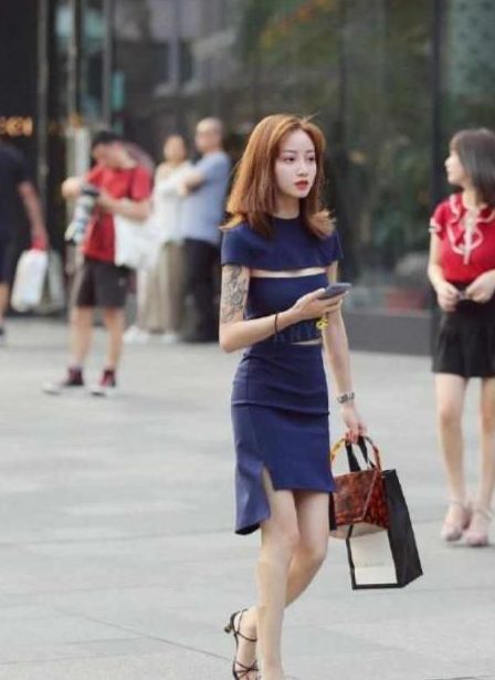  「营造」街拍：美女身穿修身短裙外搭系扣衫，浅色甜美的色调，营造出了浪漫的格调