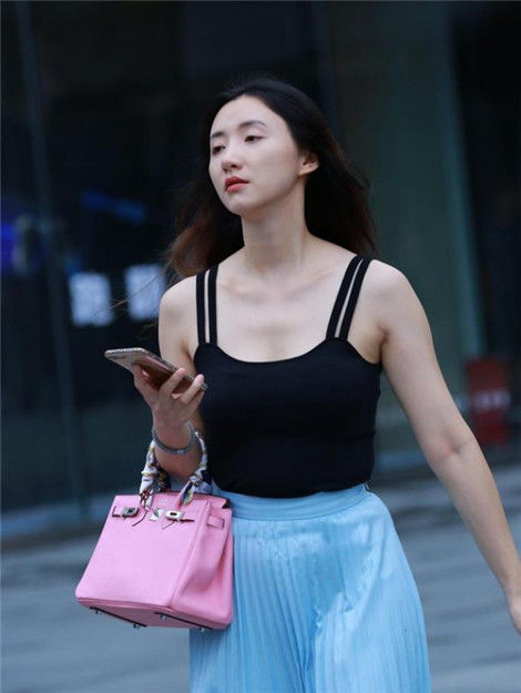  『个性』街拍：美女小姐姐穿着黑色的个性短裙，带着一个大大的太阳镜，充满无限魅力