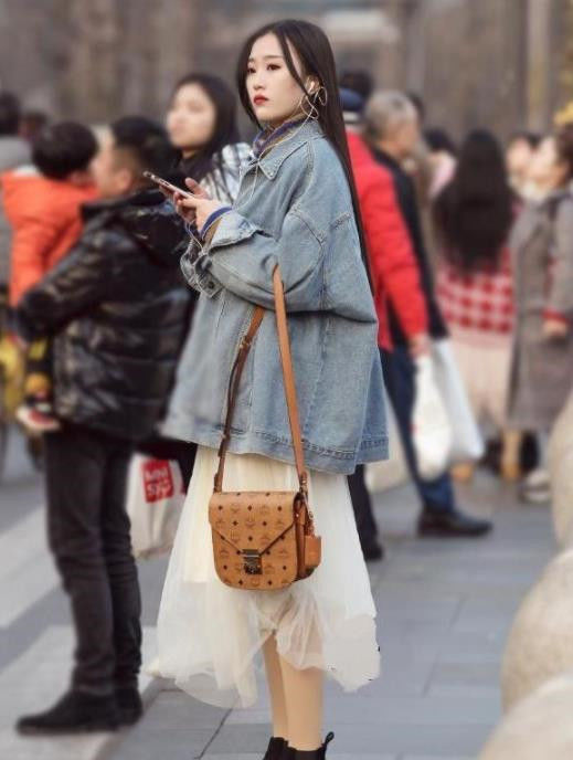  『小美女』街拍：小美女身穿紧身小吊带，左手挽了件薄外套，很显飘逸的美感