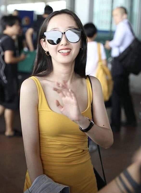 蒋梦婕穿黄色吊带裙甜美亮相机场，皮肤白皙大秀美长腿图1