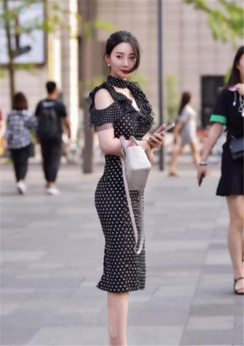  白皙：街拍：小姐姐身材窈窕，黑色短袖+背带短裤，白皙的大长腿吸睛满满