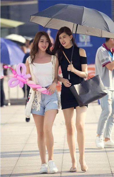  黄色：街拍：黄色长发的美女，黑色上衣搭短裤，尊贵优雅大气